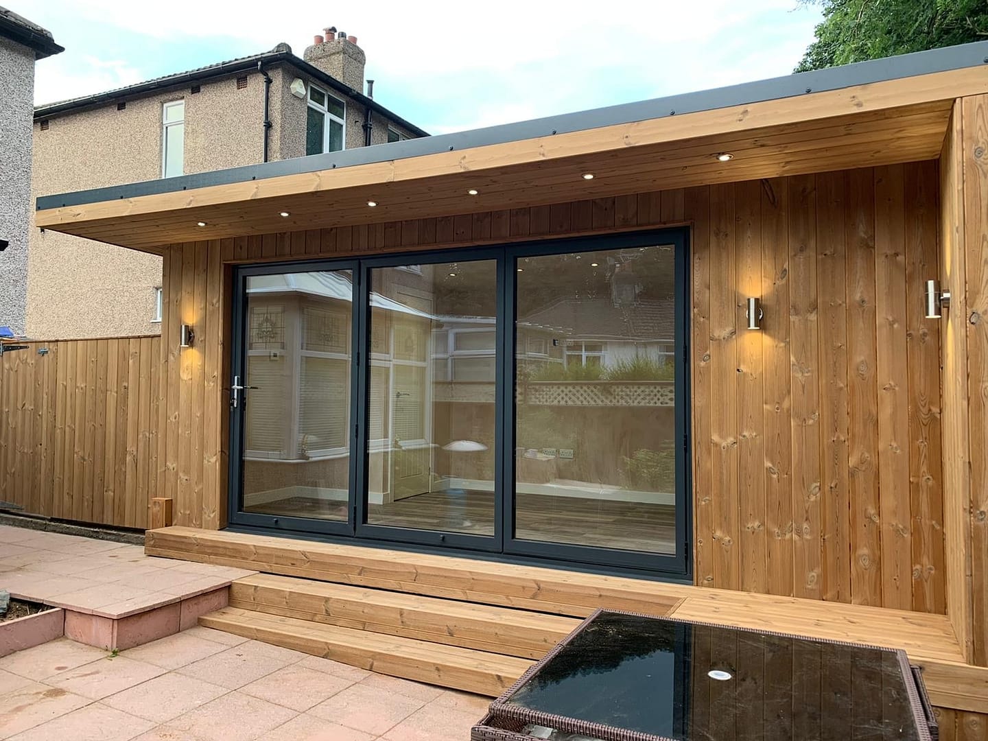 modern garden room with aluminium bifold doors and wood cladding