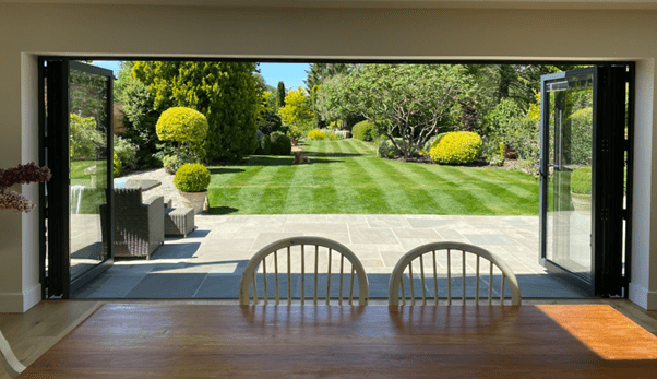 aluminium bifold doors opening up from dining room to garden