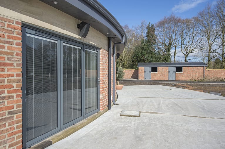 bifolding door with integral blinds on curved extension